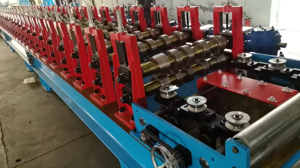 Red roller stands on a blue machine bed in a workshop