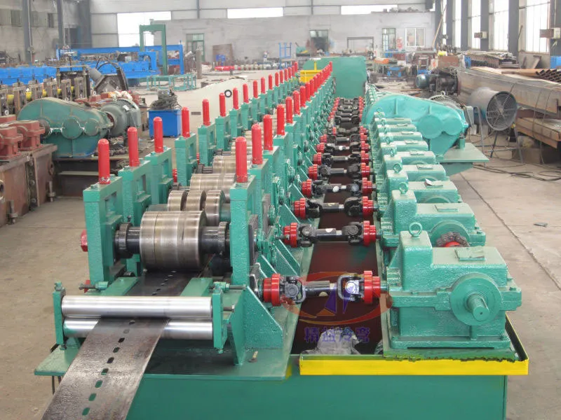 Green roller stands with red side rollers along a workshop forming line
